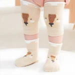 Medias y rodilleras antideslizantes beige para bebé con diseño de oso.