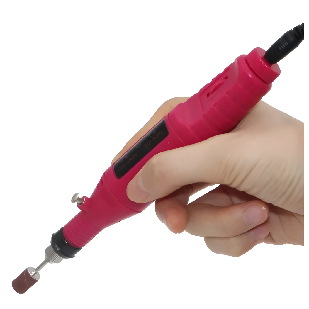 Torno eléctrico color fucsia para manicure sostenido por una mano, con punta cilíndrica de lija y cable de alimentación conectado en la parte superior.
