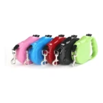 Correas retráctiles para mascota en colores rosa, azul, rojo, negro y verde, con agarre ergonómico y gancho metálico.