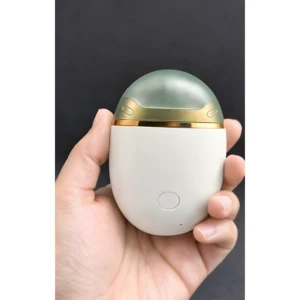 Cortauñas eléctrico blanco y dorado, con tapa verde, sostenido en mano, para cortar y limar uñas.