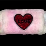 Cosmetiquera de peluche rosa y blanca con corazón de lentejuelas rojas que dice "LOVE".