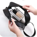 Cosmetiquera negra de cuero sintético, transparente por dentro, con dos manos organizando maquillaje.