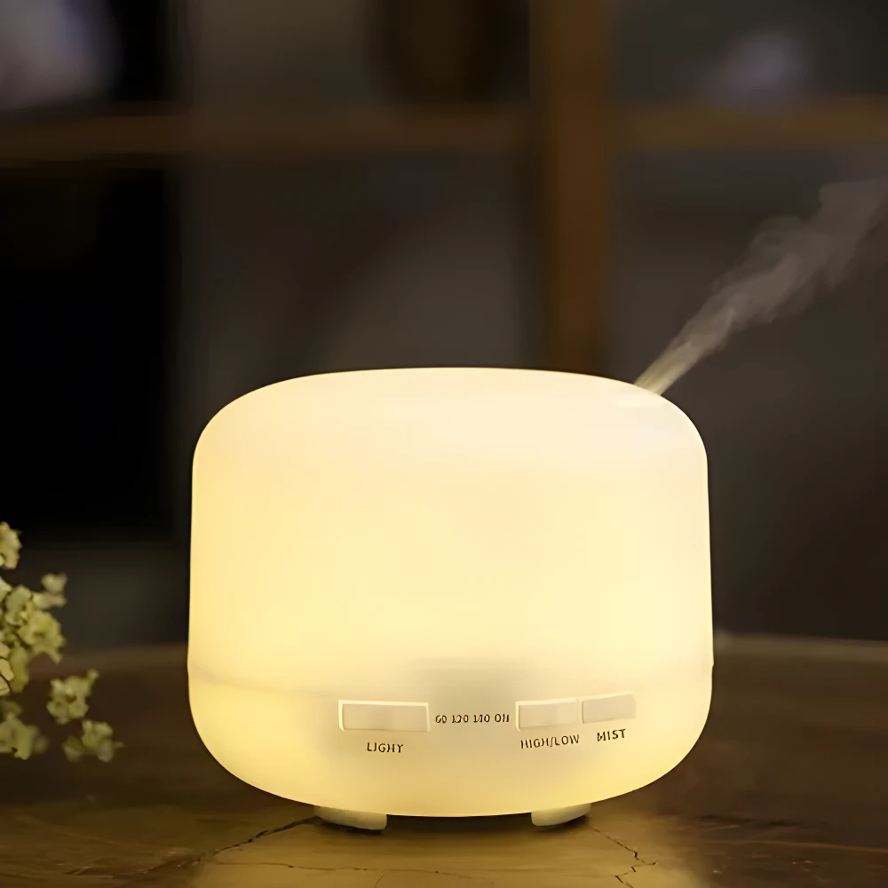 Difusor de aromas ultrasónico blanco 500 ml con vapor suave, emite luz cálida y cuenta con botones de control para luz y temporizador.