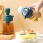 Dispensador de aceite con brocha para cocina, vertiendo aceite sobre ensalada.