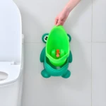 Orinal sapito verde para niños, diseñado para pared, con huevito naranja. Al lado, parte de sanitario blanco.
