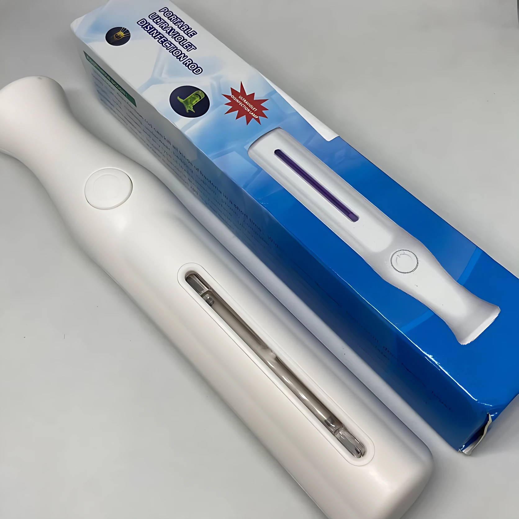Lámpara desinfectante portátil UVC, blanca, con tubo visible y caja azul de presentación.