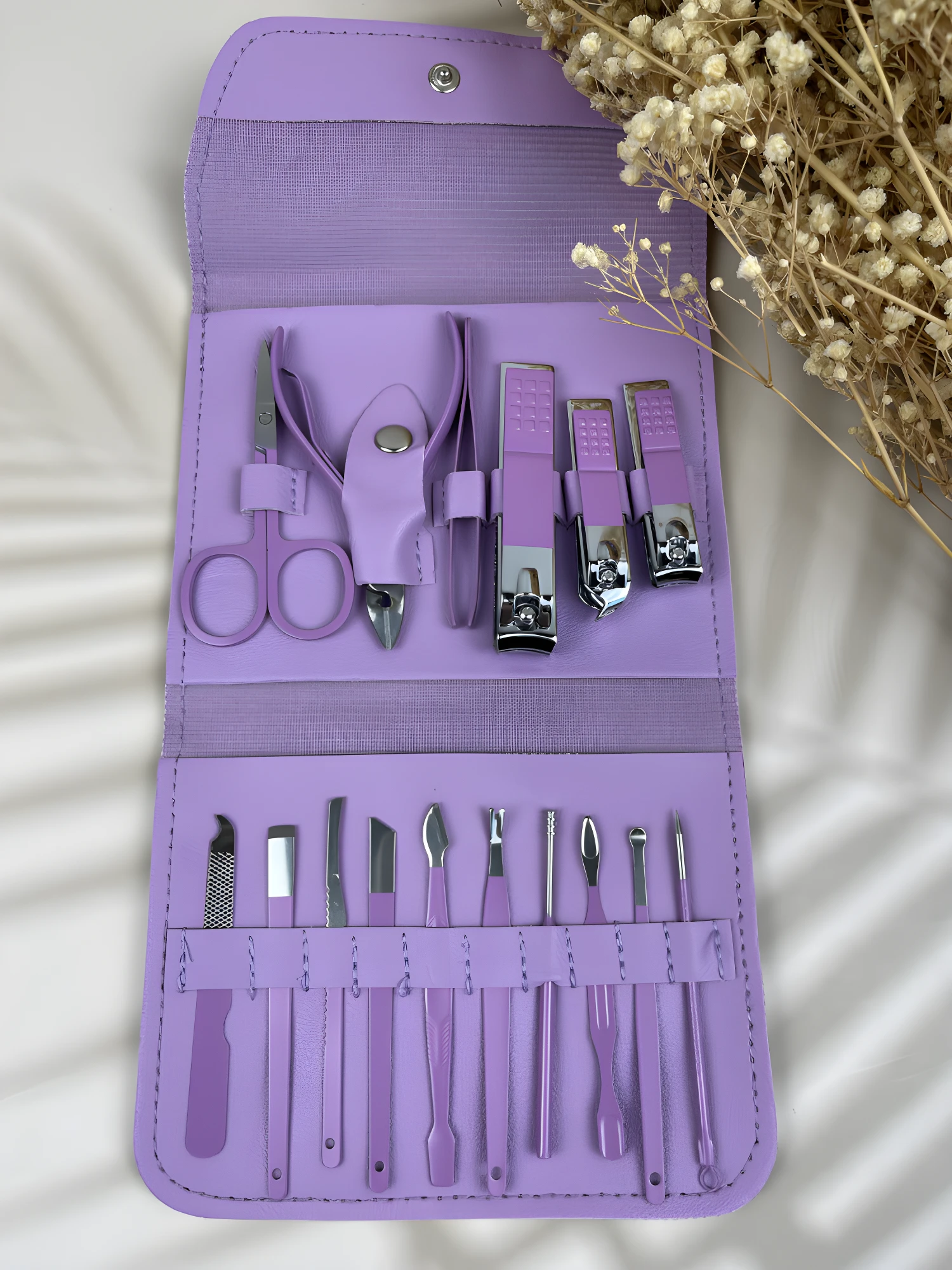 Estuche morado abierto con set completo de manicura y pedicura de acero inoxidable.