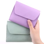 Dos estuches de manicura, uno morado y otro verde menta, sostenidos en mano.