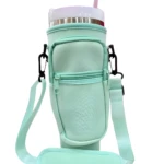 Estuche portatermo Stanley de neopreno menta con bolsillo frontal con cremallera y correa ajustable, protege tu bebida.