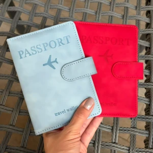 Set x2 fundas de viaje para pasaporte, una azul claro y otra roja, con avión y texto "travel wallet".