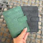Set x2 fundas de viaje para documentos, verde y gris, con avión grabado, sobre mesa tejida.