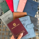 Set de 2 fundas de viaje para pasaporte en colores azul claro y gris, con diseño de avión y costuras visibles.