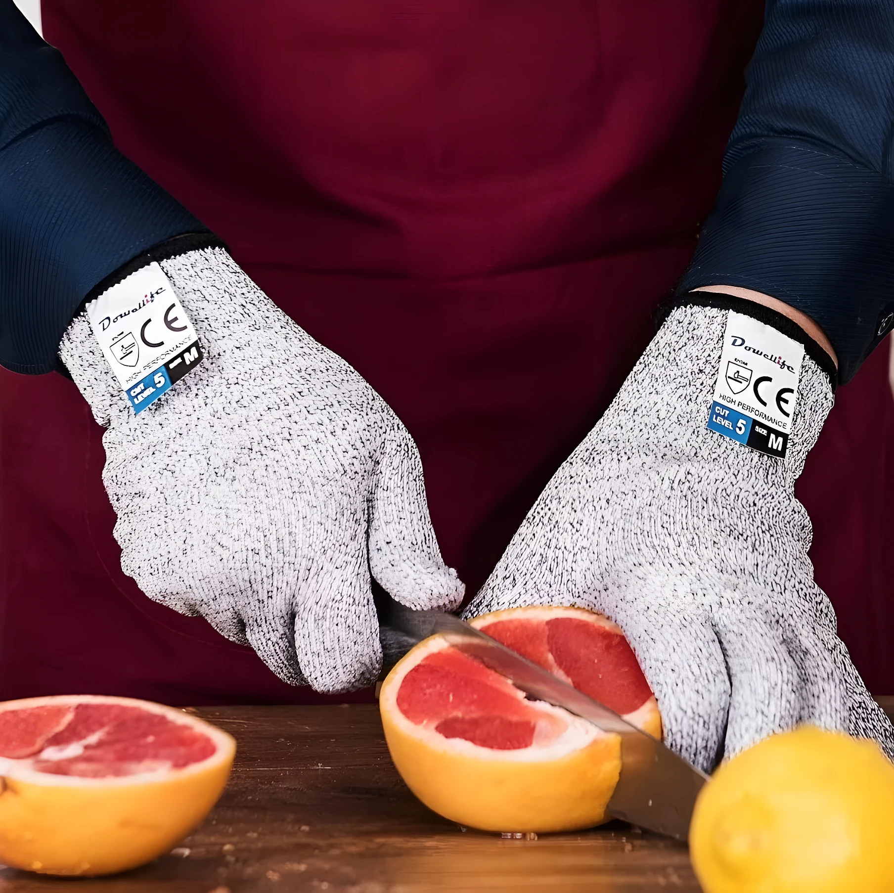 Guantes anticorte nivel 5 de textil gris y negro, talla M, protegen manos al cortar cítricos.