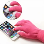Guantes rosados de tela para pantalla táctil de celular, detalle de dedos con punta gris.