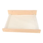 Hamaca de pared para gato en madera clara con superficie de felpa blanca y ventana panorámica.
