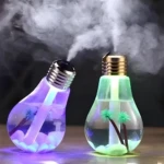 Humidificador difusor de aromas en forma de bombilla, uno morado con piedras blancas y otro verde con palmeras, emiten vapor.