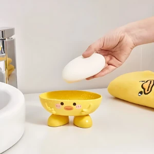 Jabonera amarilla de patito con jabón en mano, ideal para niños, decora el baño.