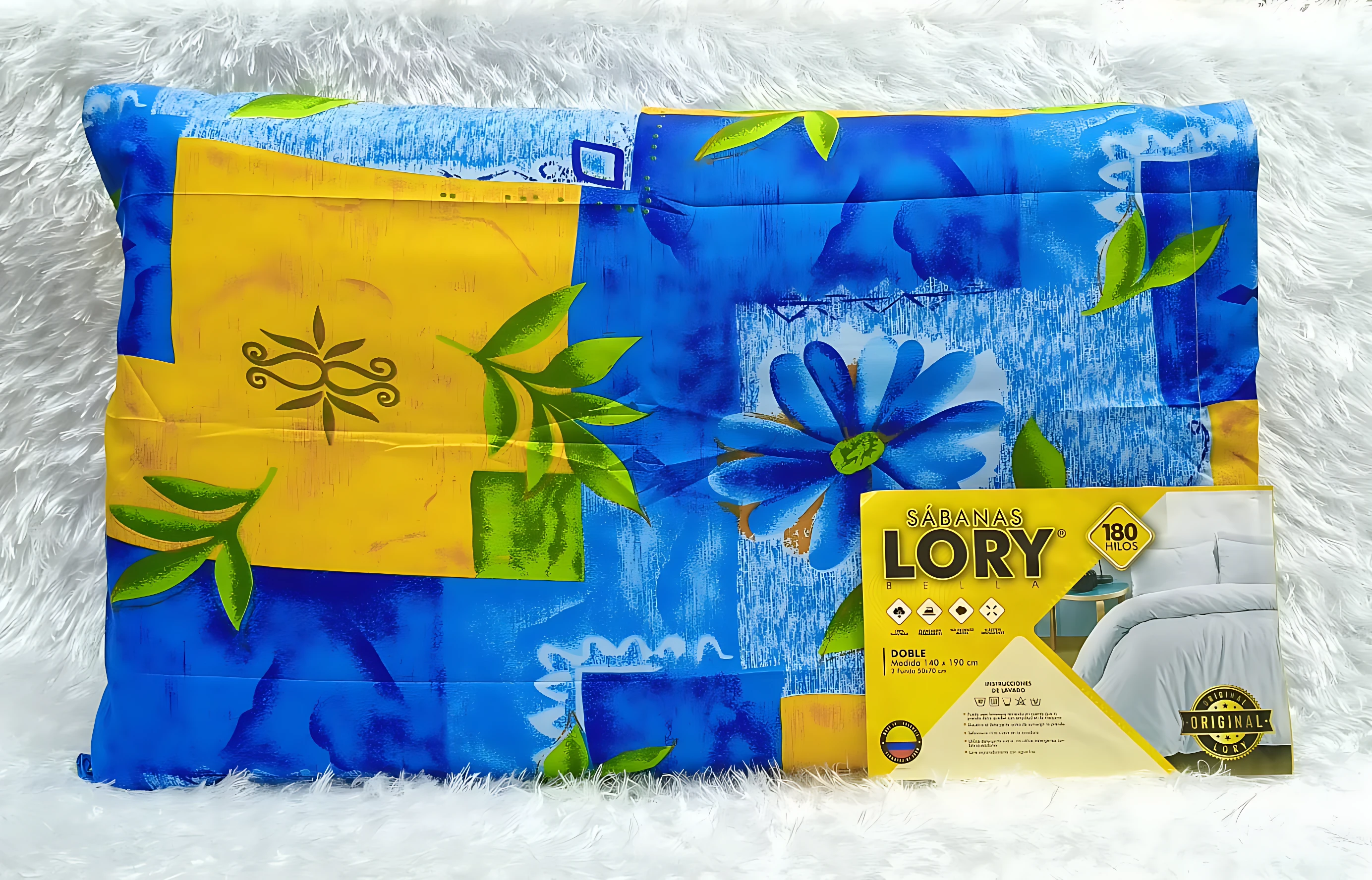 Juego de sábanas Lory 180 hilos, tamaño doble (140x190 cm), diseño azul con flores y detalles amarillos, sobre fondo blanco esponjoso.