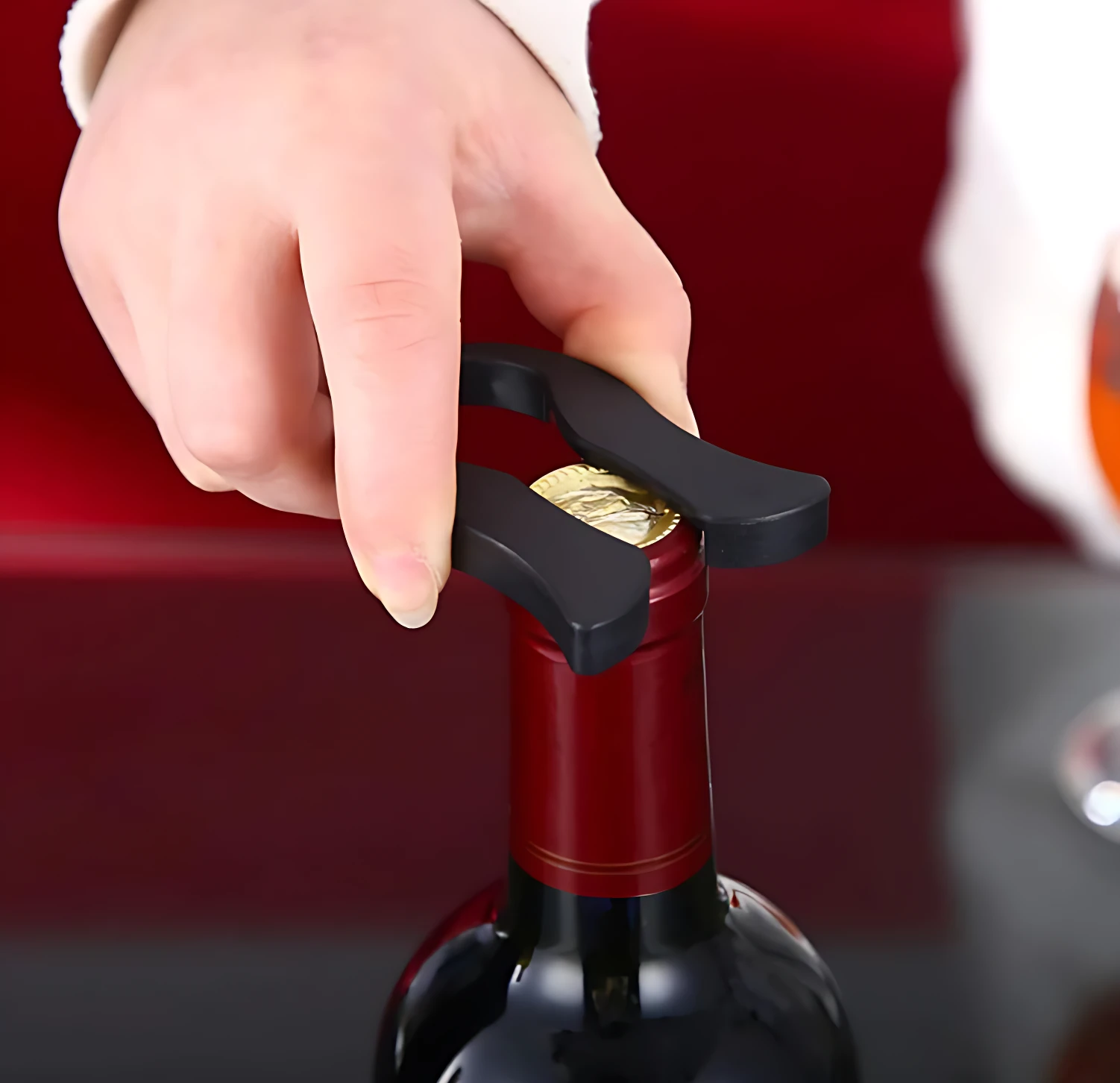 Sacacorchos de presión de aire negro abriendo botella de vino tinto con cortador de cápsula.