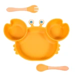 Vajilla adherente naranja en forma de cangrejo con cubiertos de madera.