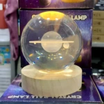 Lámpara de noche bola de cristal 3D con escena planetaria y base de madera iluminada.