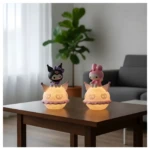Lámpara LED infantil Kawaii Kuromi, con figura de personaje negro, base redonda iluminada rosa con corazones.