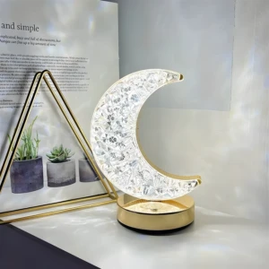 Lámpara LED de luna dorada y cristal texturizado, ideal para crear ambiente relajante en dormitorio infantil.