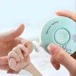 Lima eléctrica para bebé en color verde menta recortando uñas delicadamente.