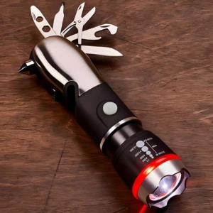 Linterna LED multiusos plateada y negra con múltiples herramientas desplegadas, sobre madera.