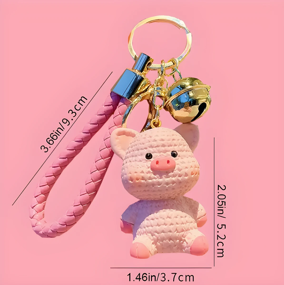 Llavero rosa con figura de cerdo sentado, cascabel dorado y correa tejida, 9.3 cm de largo.