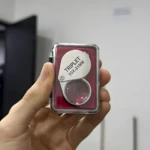 Lupa joyero plegable con estuche rojo, 30x-21mm, sostenida en mano.