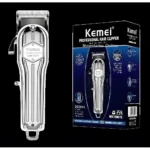 Máquina cortadora de cabello inalámbrica Kemei 1977 color plateado metálico con textura estriada, junto a su caja con batería de 2500 mAh y modelo visible.