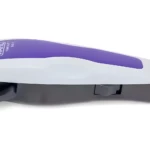 Máquina cortadora de cabello Wahl blanca y morada con cuchillas de acero, palanca de ajuste lateral y cable de conexión eléctrica, vista de perfil.