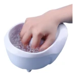 Máquina spa para manicure con mano sumergida en agua burbujeante y morada.