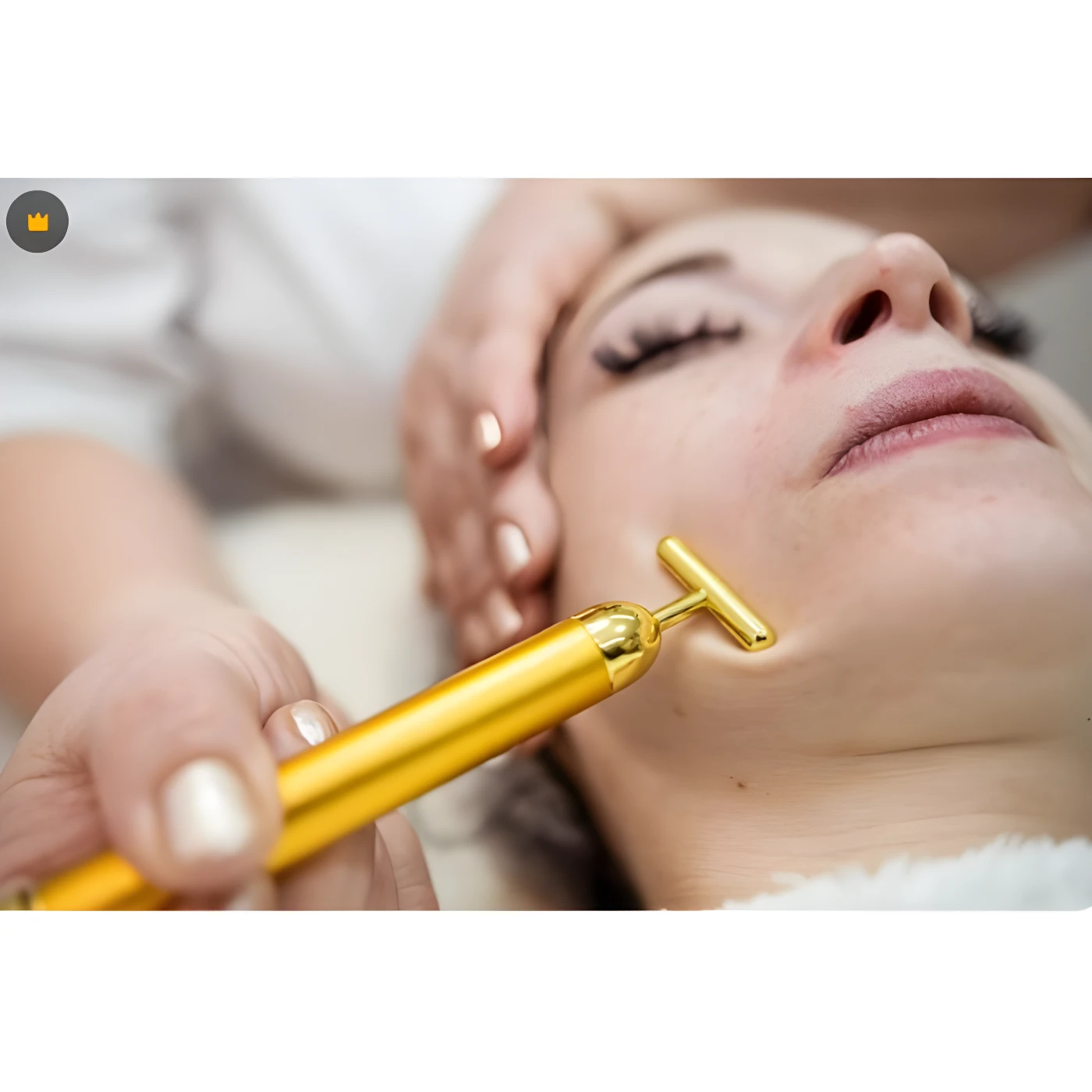 Rodillo facial dorado en T para masaje de piel, usado por esteticista.