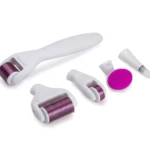 Kit de masajeador facial y corporal 6 en 1 con rodillos morados y cepillo fucsia sobre fondo blanco.
