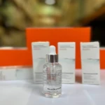 Serum Niacinamida en frasco de vidrio con gotero, fondo naranja, 30ml.