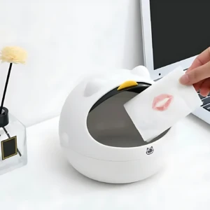Mini basurero blanco con diseño de gato, tapa superior amarilla, para escritorio. Mano deposita pañuelo con labial.