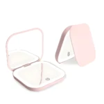 Set x2 mini espejos rosados con luz LED, uno abierto mostrando espejo y luz, otro cerrado en forma de tríptico.