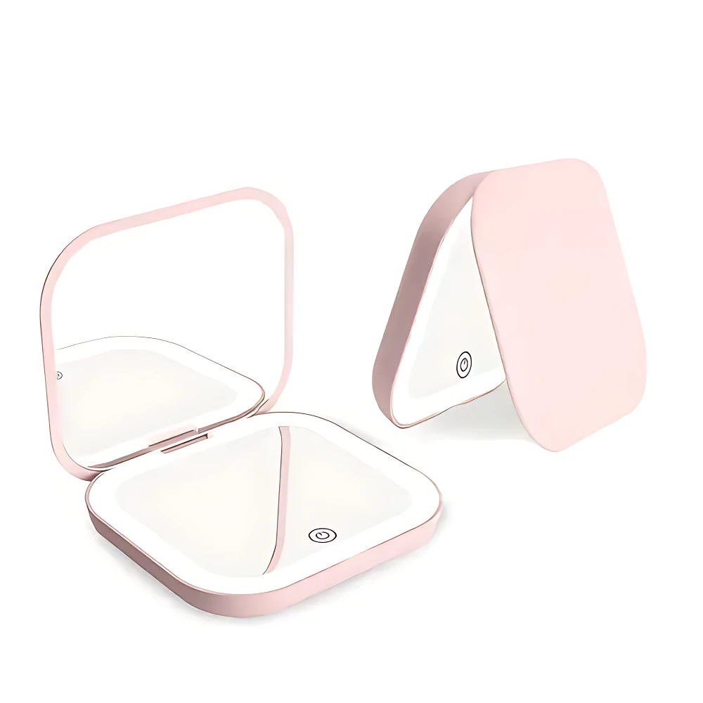 Set x2 mini espejos rosados con luz LED, uno abierto mostrando espejo y luz, otro cerrado en forma de tríptico.