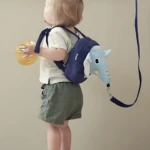 Mochila arnés azul con diseño de elefante para bebé, con correa de seguridad.