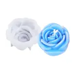 Molde de silicona flexible para repostería junto a una vela azul con forma de rosa detallada, ideal para manualidades y decoración de postres.
