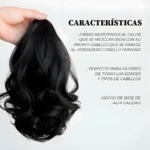 Mano sosteniendo moño postizo negro con ondas, fibras resistentes al calor de aspecto natural y base de alta calidad para peinados fáciles y elegantes.