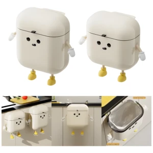 Papelera de cocina colgante color crema con diseño de personaje animado. Muestra en pared y sobre mesón.