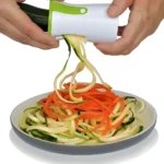 Rallador espiral blanco y verde que convierte calabacín y zanahoria en fideos para ensaladas saludables.
