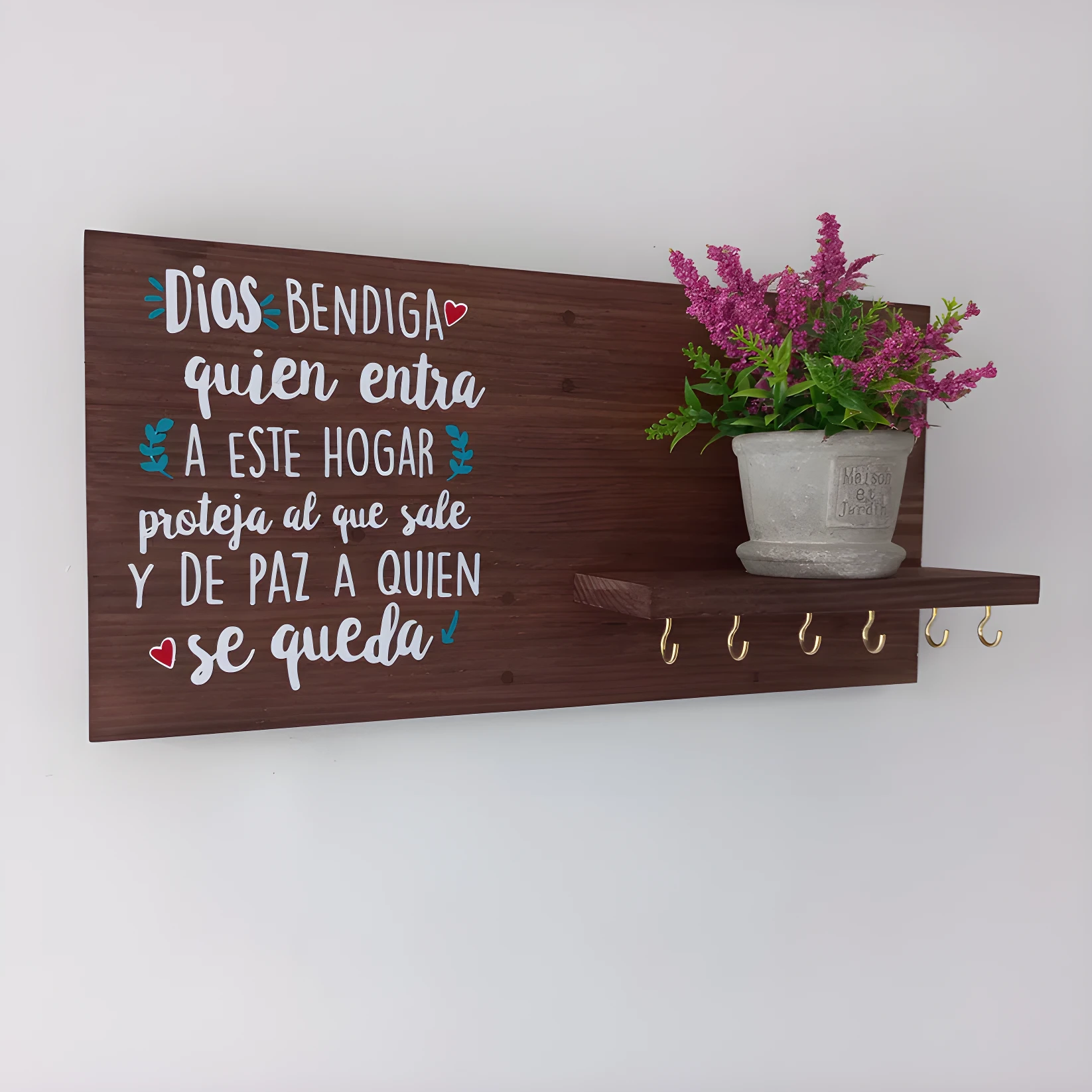 Perchero de madera pino con frase "Dios bendiga quien entra", maceta con flores y 6 ganchos dorados.