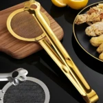 Set x2 pinzas de cocina doradas y plateadas con diseño de huella, una con colador integrado, ideales para freír y servir alimentos.