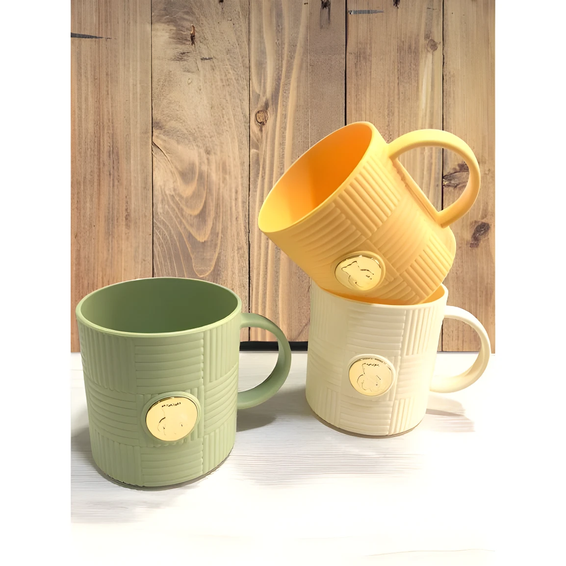 Set de 2 pocillos de cocina verdes y crema con relieve y sello dorado, ideales para café o té.