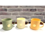 Set x2 pocillos verdes, beige y naranja con relieve y sello dorado, ideales para cocina.