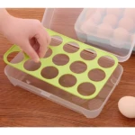 Porta huevos canasta plástico verde con compartimentos, sujetado por mano, sobre base transparente.